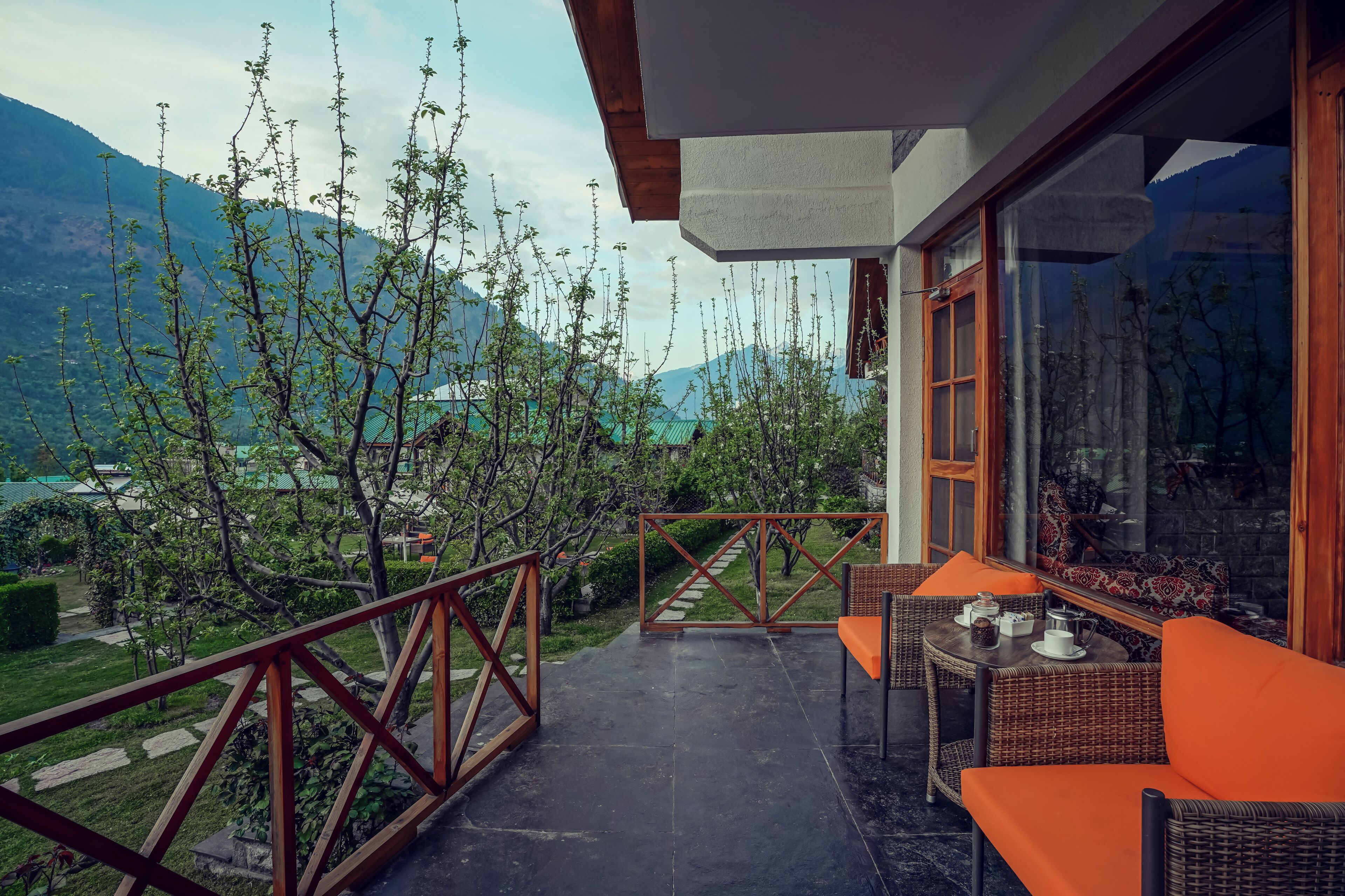 A balcony with wicker furniture and a view of mountains.