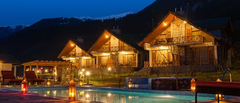 Una piscina al aire libre, sombrillas, tumbonas