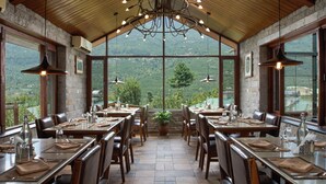 A restaurant with multiple tables, chairs, and hanging lights. - Larisa Resort, Manali (Manali)