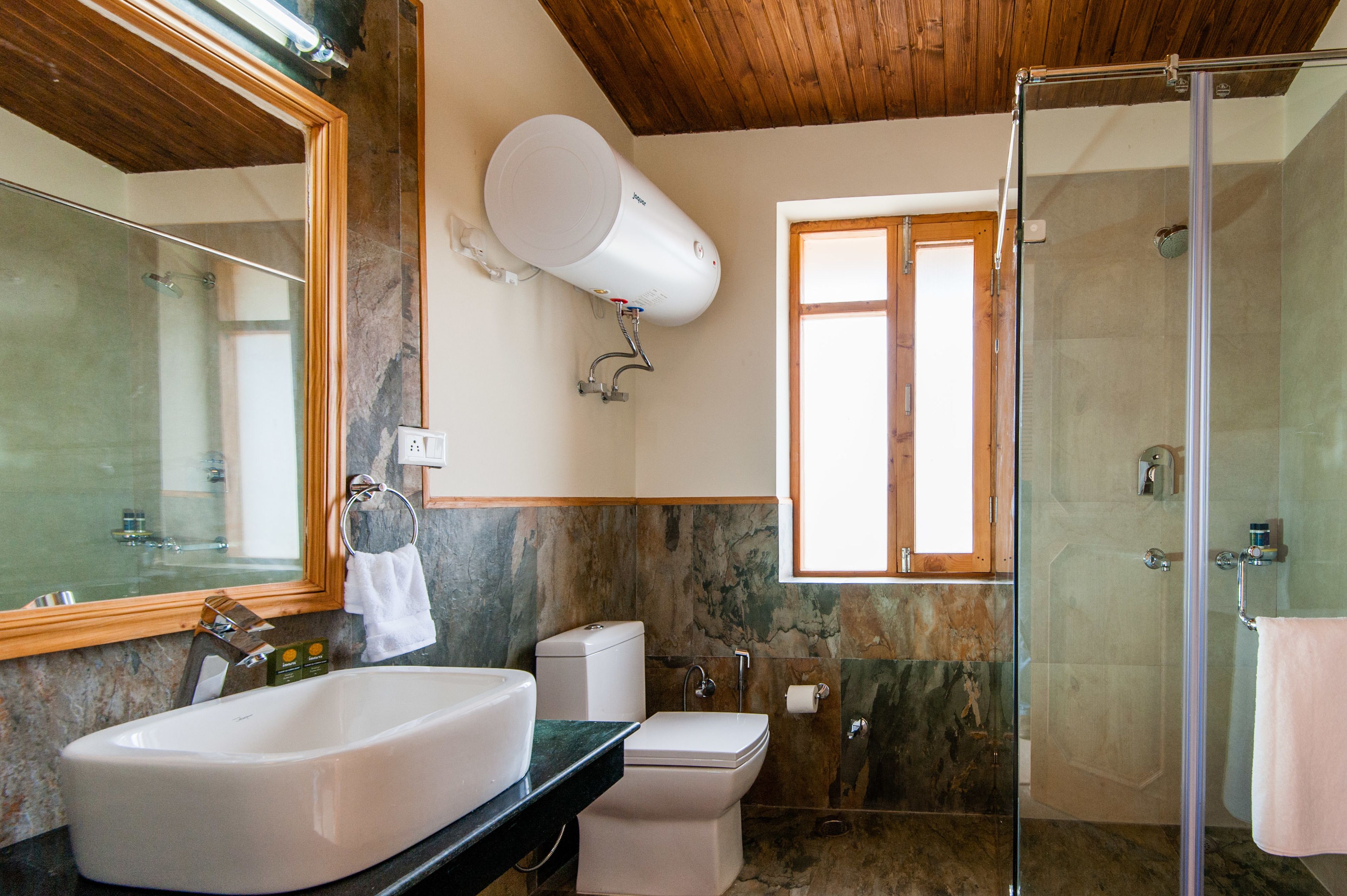 A bathroom with a large sink, toilet, and shower.