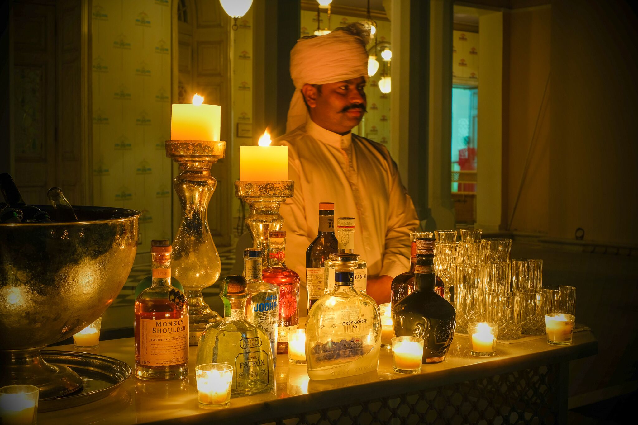 A bar area with various liquor bottles, glasses, and candles.