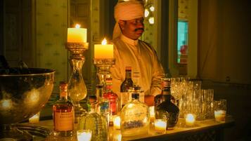 A bar area with various liquor bottles, glasses, and candles.