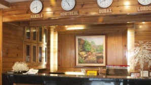 A wooden reception desk with clocks indicating time in Montreal, Dubai, and London. - Hotel Cosmopolitan (Baguio)