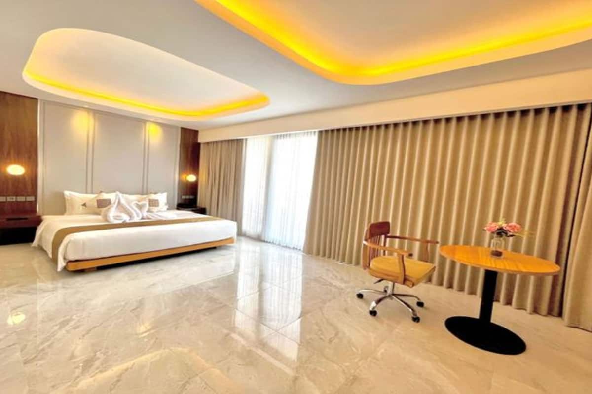 Une chambre d’hôtel moderne, dotée d’un grand lit, d’un bureau et d’une chaise.