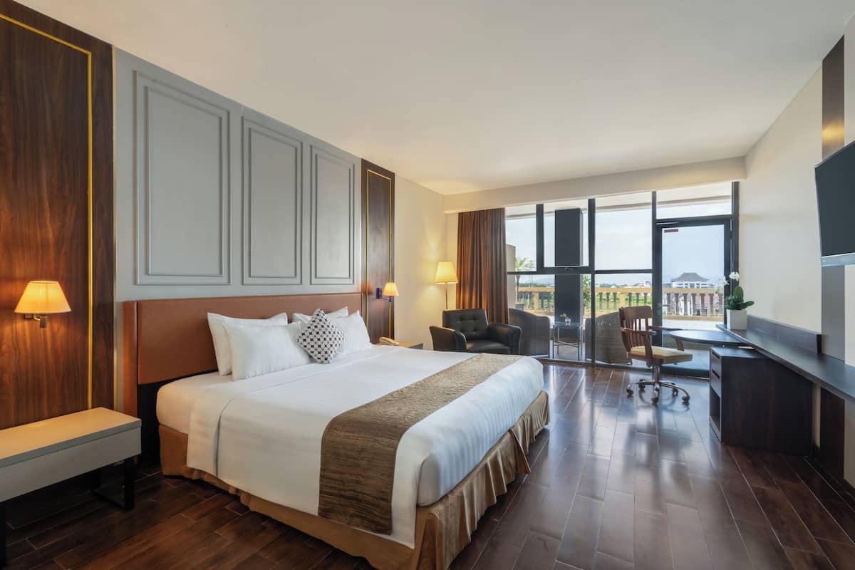 Une chambre d’hôtel avec un grand lit, un bureau et une vue sur la ville.