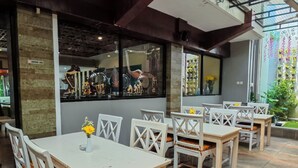 Un restaurant doté d’une terrasse, d’un sol en pierre et offrant une vue sur le jardin.