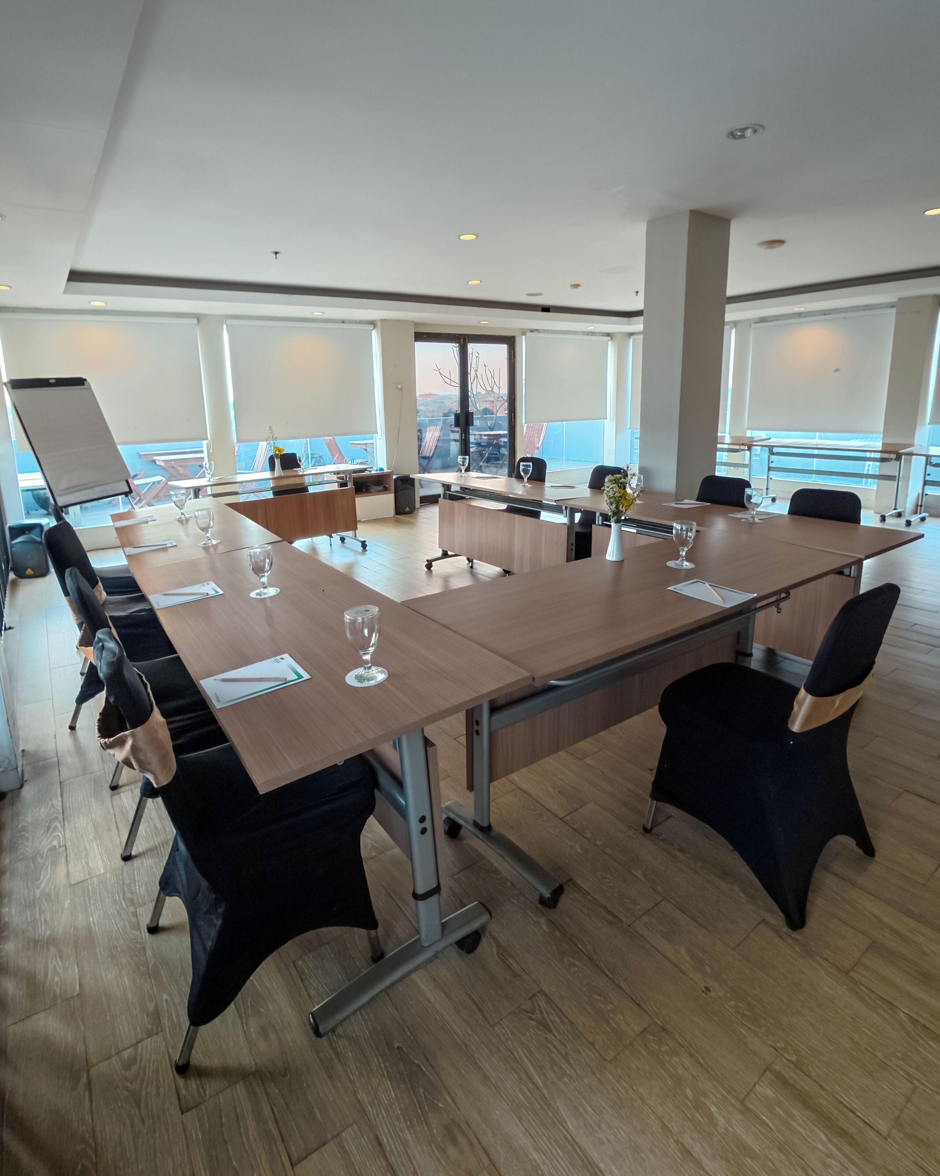 A conference room with a large table, chairs, and a view through the windows.