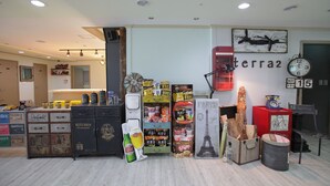 Una habitación con varios muebles para guardar objetos, un reloj y un calendario en la pared.
