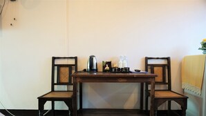 A small wooden table with two chairs, a kettle, and a few bottles on it. - My Mum Home (Chiang Mai)