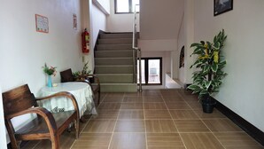 A staircase leading to an upper floor, a dining area with a table and chairs, and a potted plant. - My Mum Home (Chiang Mai)