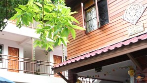 A wooden house with a balcony, a covered porch, and a bicycle parked outside. - My Mum Home (Chiang Mai)