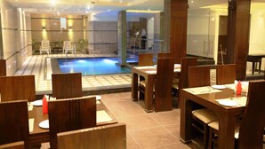 Un restaurante con zona de piscina, mobiliario de madera y diseño de interiores moderno.