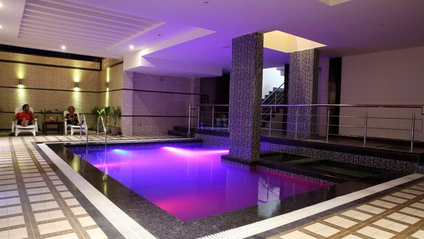 Una piscina con suelo de azulejos y un pilar central.
