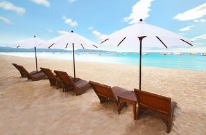 A beach with rows of wicker lounge chairs and white umbrellas. - The Rose Pike at Boracay (Boracay Island)