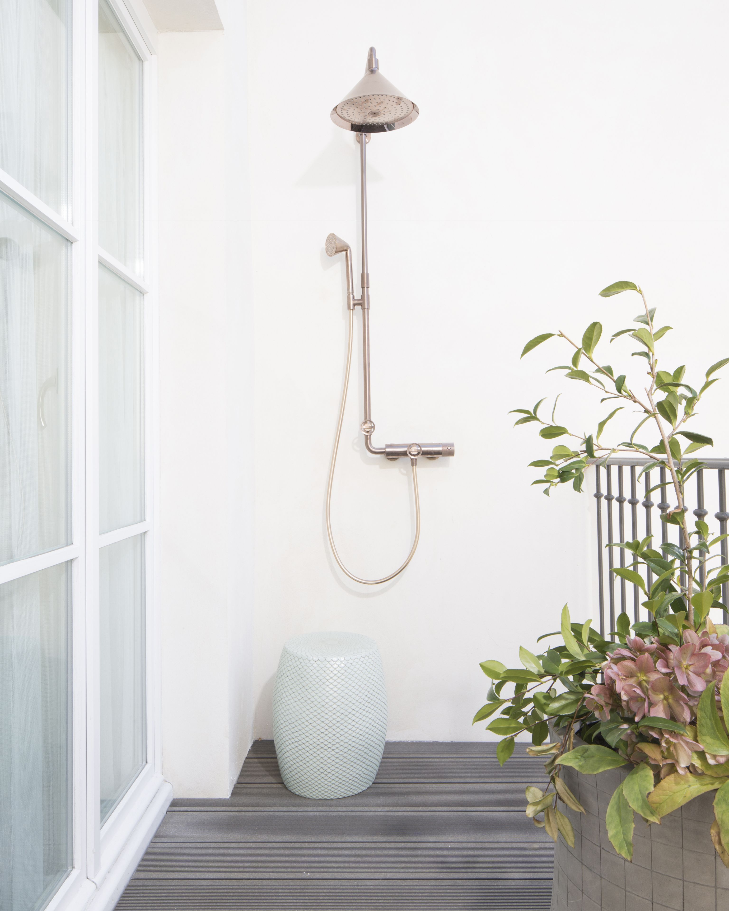 A shower with a handheld showerhead and a rain shower head mounted on a wall.