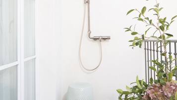 Una ducha con cabezal de ducha de mano y ducha lluvia fijada en la pared.