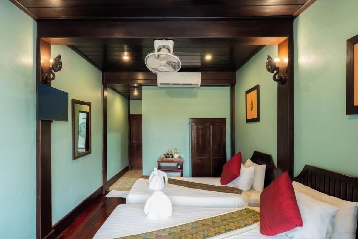 Una habitación de hotel con cama, escritorio, silla y espejo.