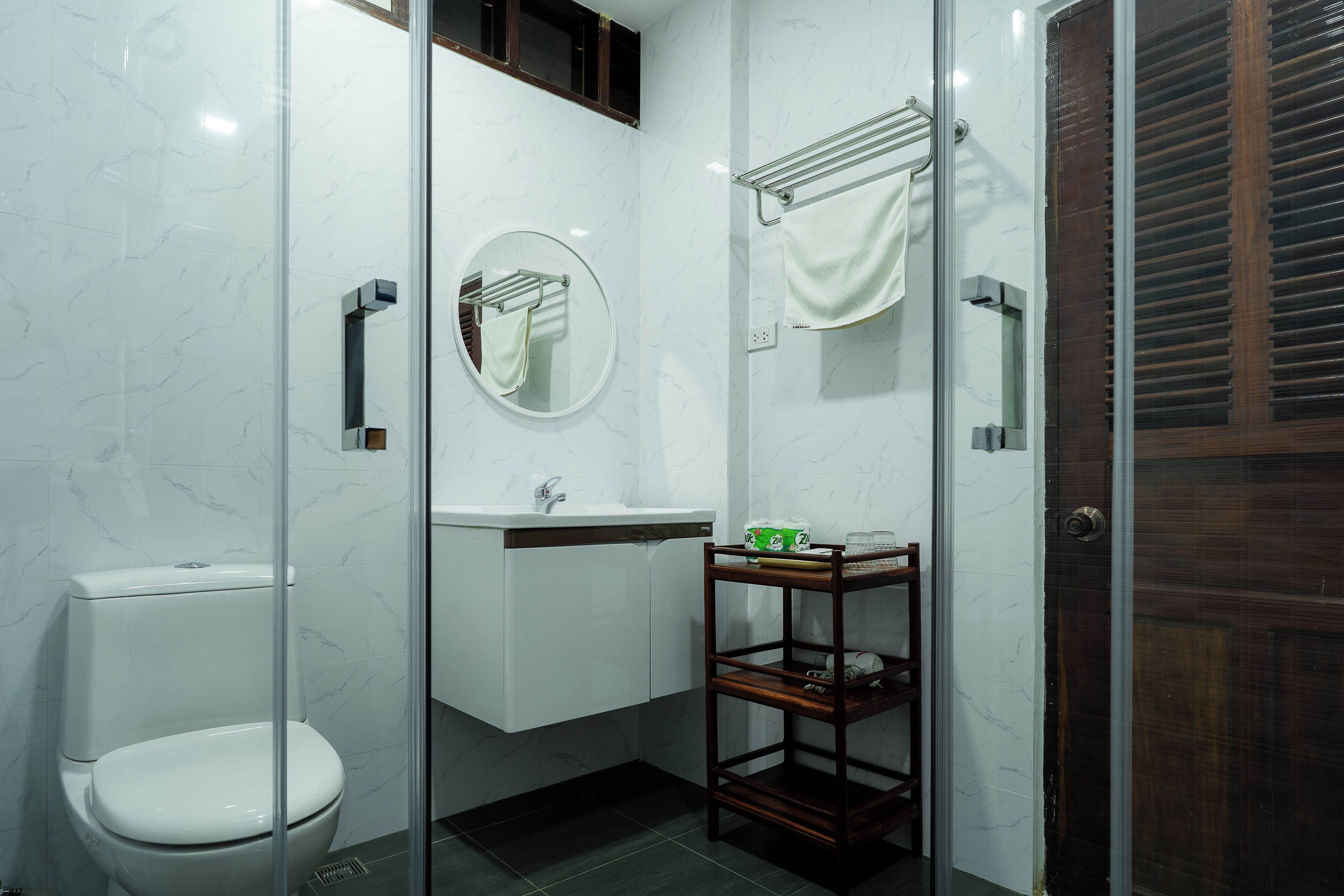 A modern bathroom with a toilet, sink, and glass shower enclosure.