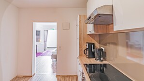 A modern kitchen with a built-in stove, a coffee maker, and a microwave. - Tannenblick (Bad Vilbel)