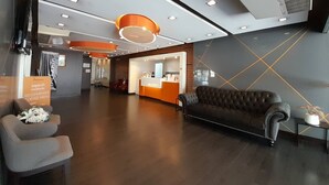 A modern lobby with a reception desk, seating area, and a coffee menu sign. - 14 Living (Bangkok)
