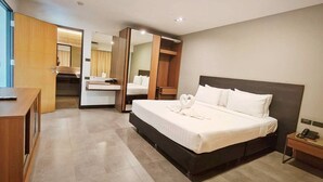 A modern hotel room with a large bed, a wooden desk, a vanity with a mirror, and a wardrobe. - 14 Living (Bangkok)