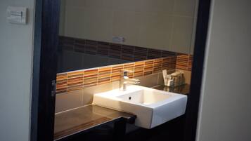 A bathroom with a white sink, a mirror, and a tiled backsplash.