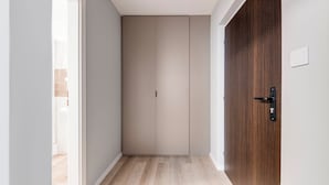 A hallway with a wooden door and a beige wardrobe. - Hotel Koruna (Prague)