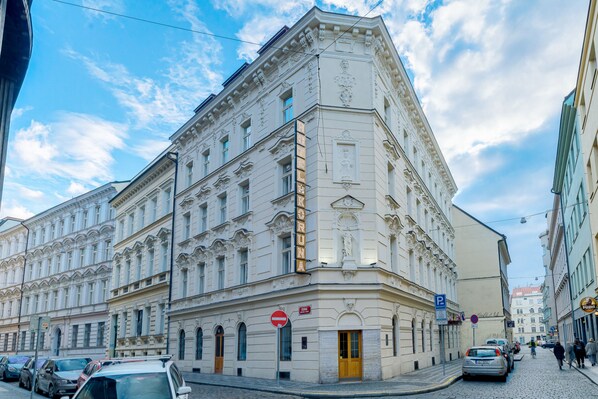 A historic building with classical architecture, a corner entrance, and a cobblestone street. - Hotel Koruna (Prague)