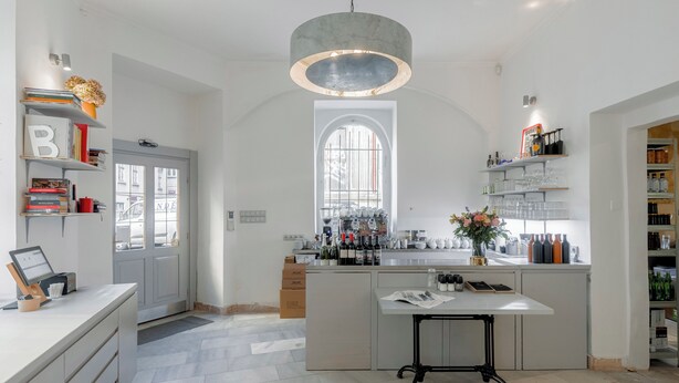 A modern kitchen with a central island, built-in shelves, and a large window. - Hotel Koruna (Prague)