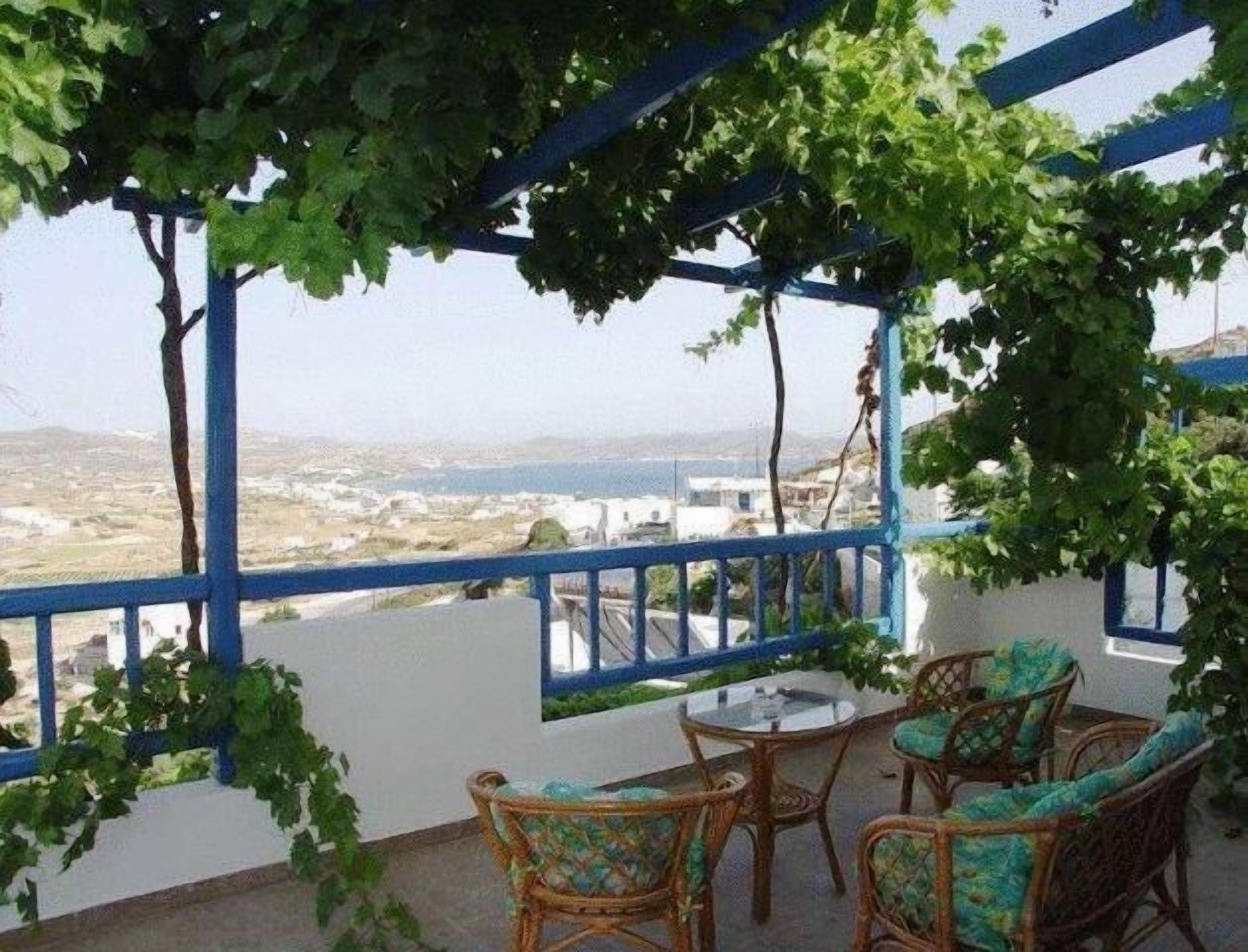A terrace with wicker furniture and a view of the landscape.