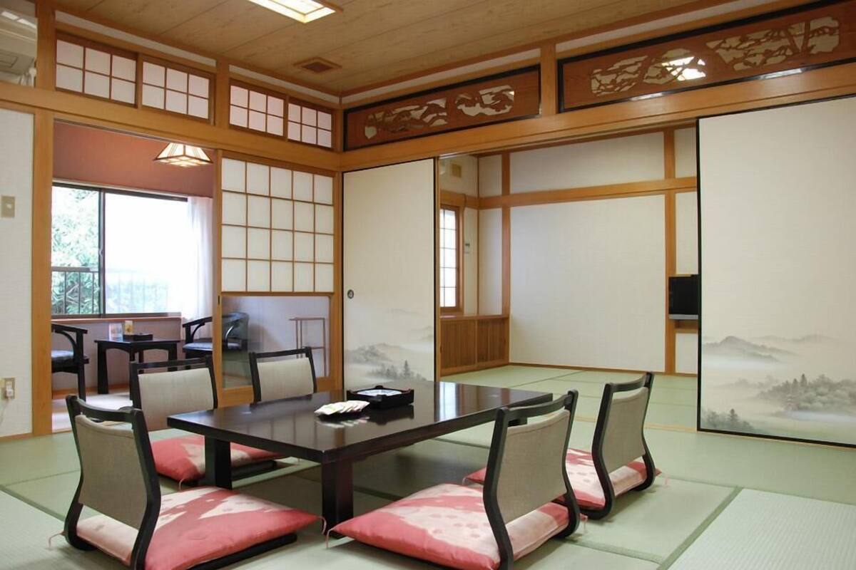 A traditional Japanese-style room with tatami flooring, a low table, and shoji screens.