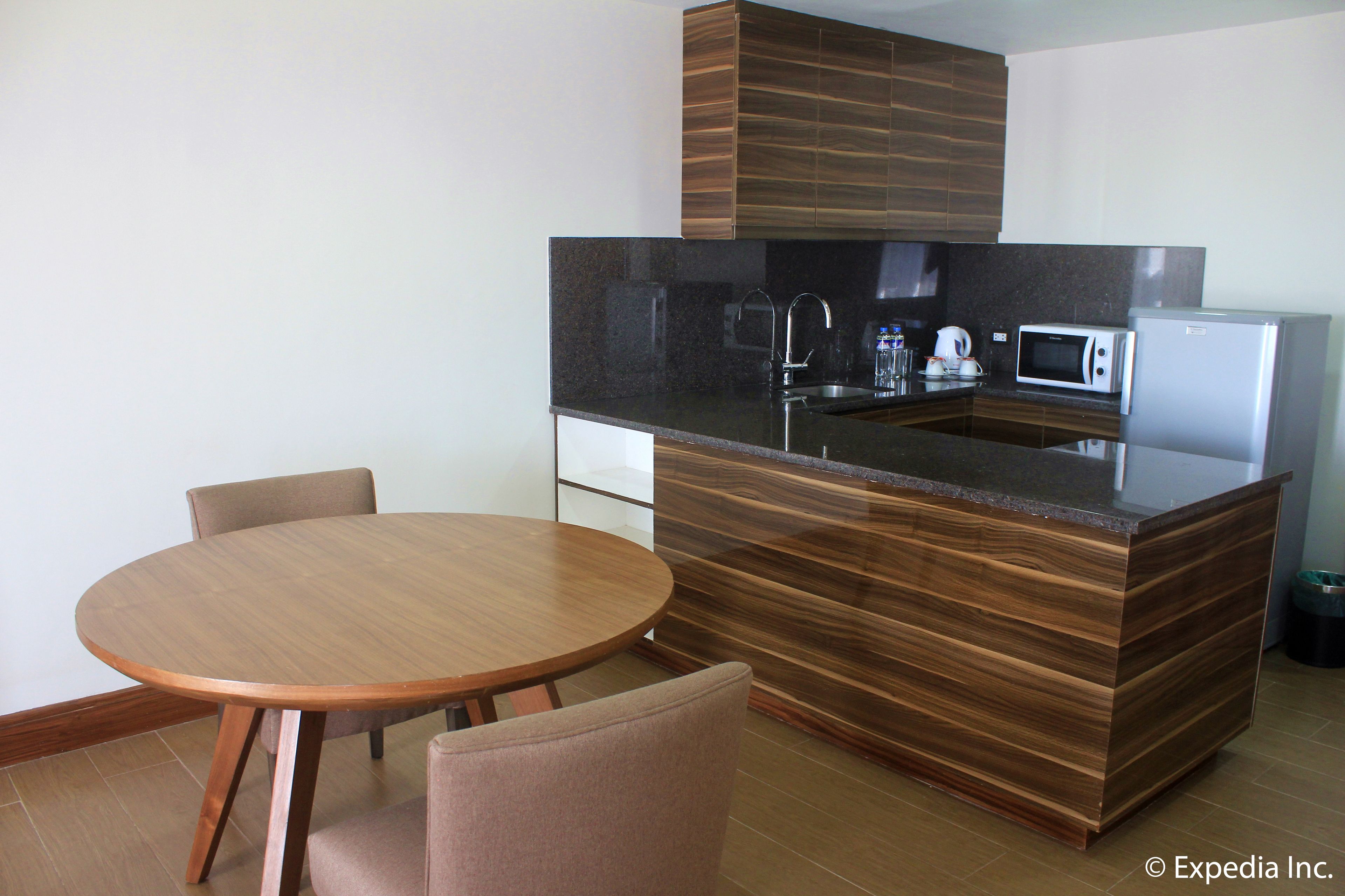 A modern kitchen with a central island, built-in appliances, and a round dining table with chairs.