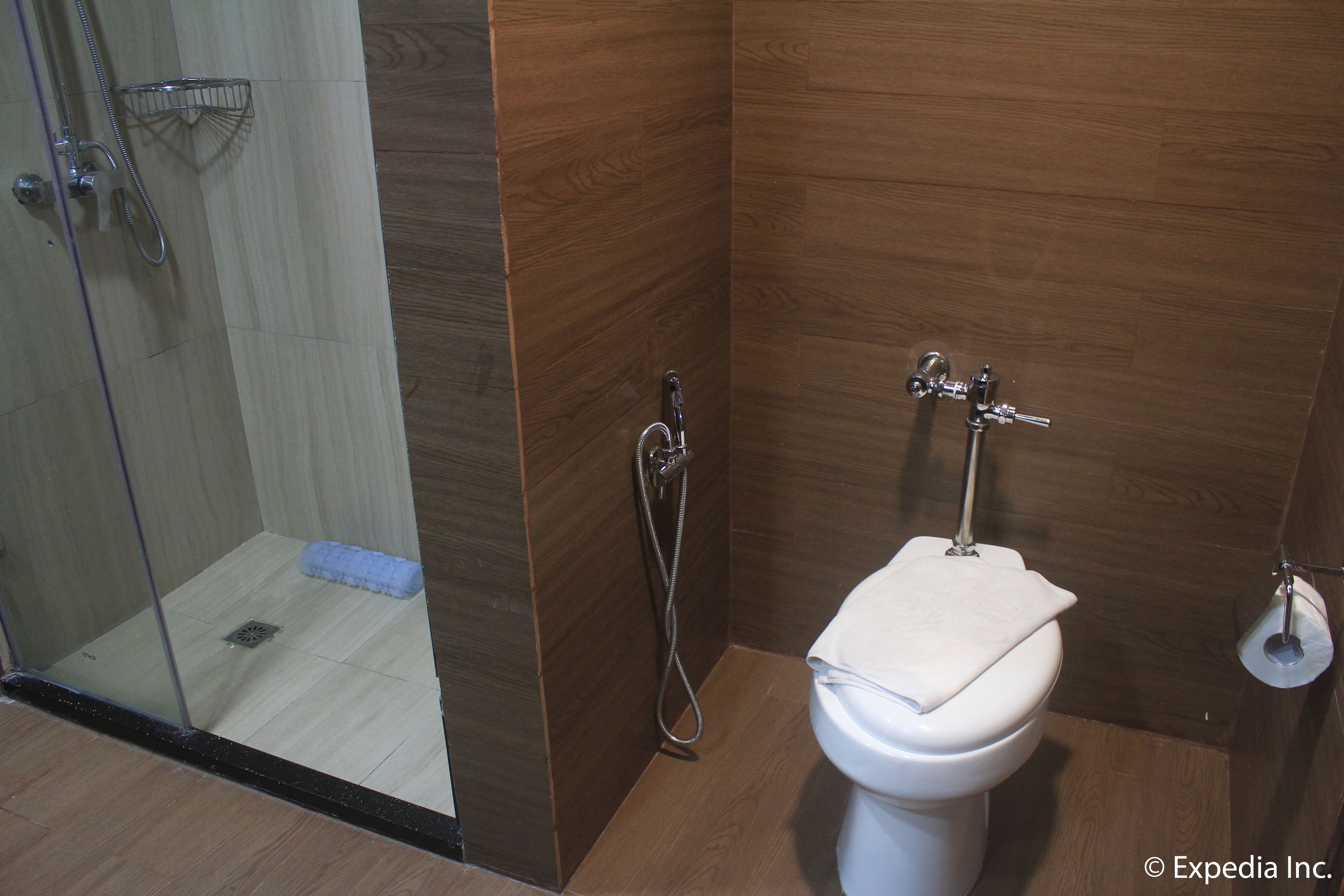 Ein Badezimmer mit Dusche, Toilette und einer Duschkabine aus Glas.