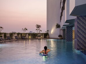 Una piscina al aire libre, tumbonas