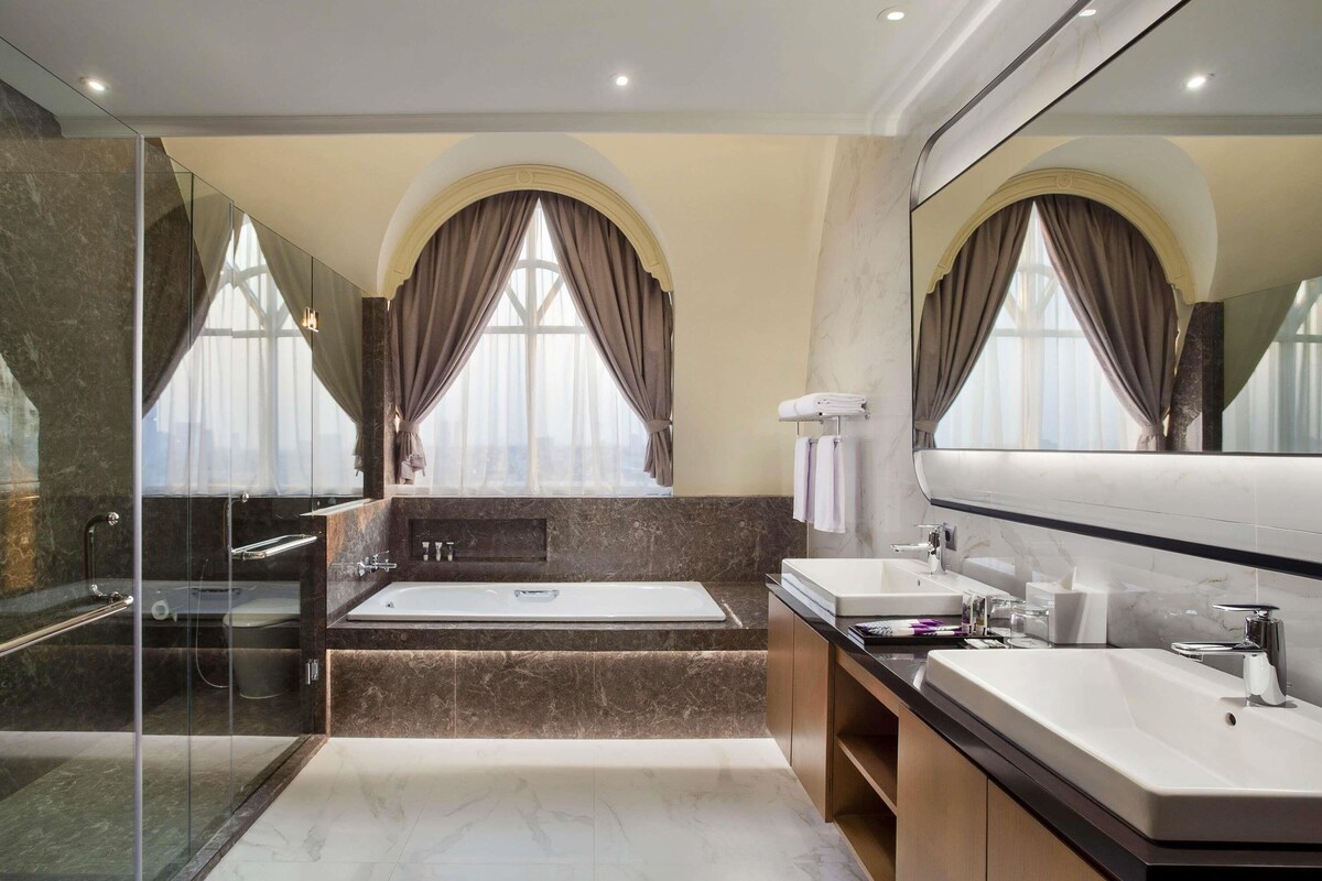 A modern bathroom with a bathtub, a shower, and a vanity with a mirror.