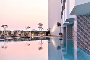 Una piscina al aire libre, sillones reclinables de piscina