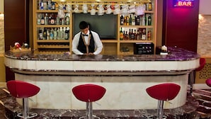 A bar area with a bartender, a neon sign reading "ABEL BAR", and a variety of bottles on shelves. - Abel Hotel (Istanbul)