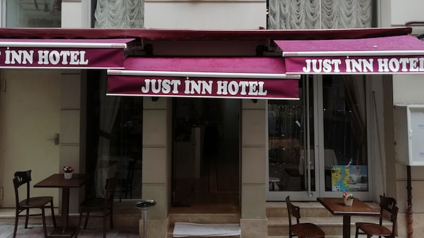 The exterior of the Just Inn Hotel with a prominent sign and awning displaying the hotel's name. - Just Inn Hotel (Istanbul)