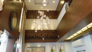 A restaurant with a high ceiling, pendant lighting, and a green upholstered booth. - Just Inn Hotel (Istanbul)