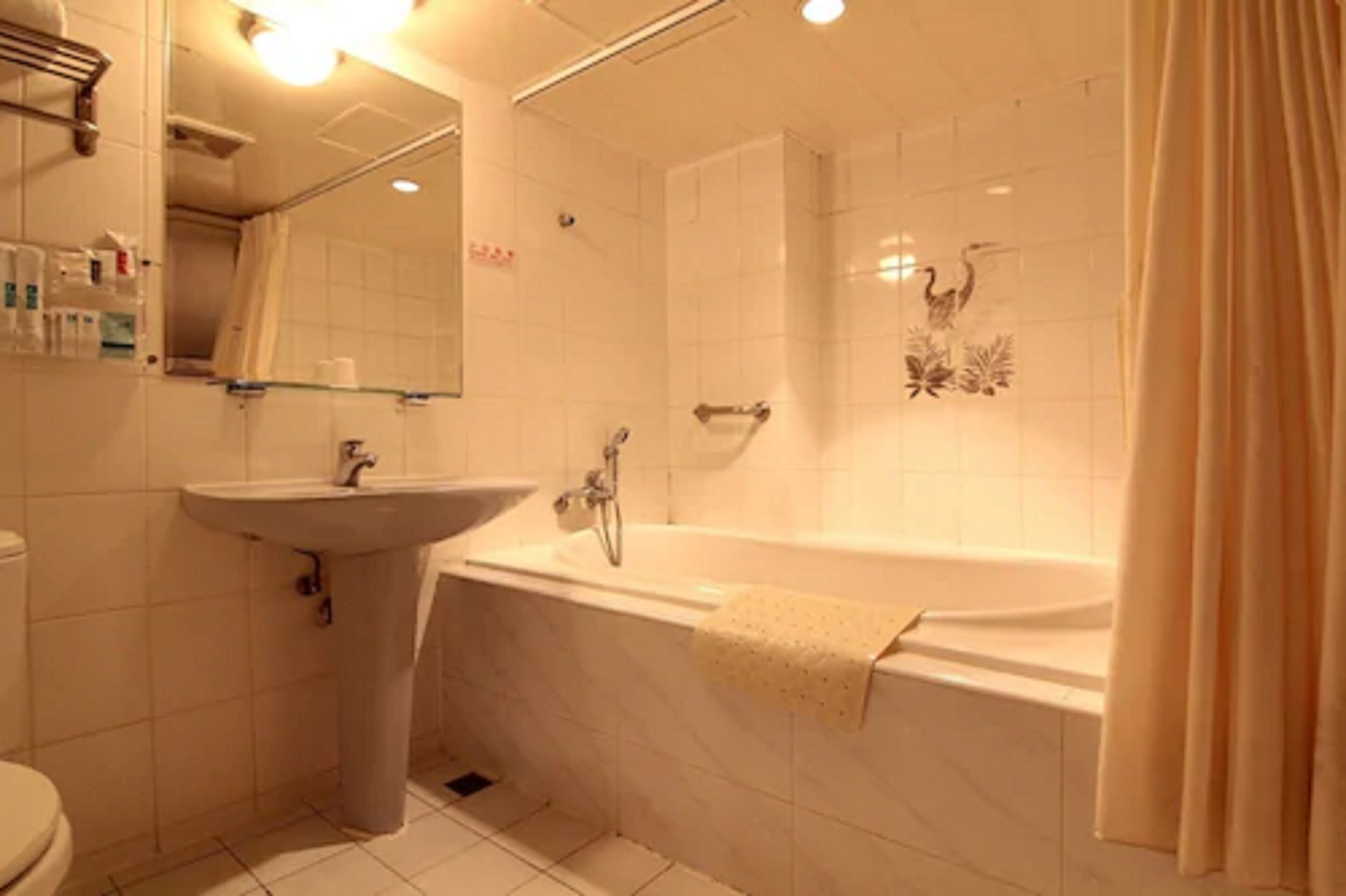 Een badkamer met een wastafel, spiegel en bad.