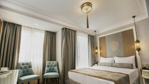Une chambre d’hôtel avec un grand lit, deux chaises, un bureau et une table de chevet.