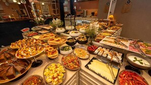 Un buffet proposant une variété de plats, notamment des pizzas, des salades et des viandes.