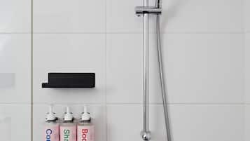 A modern bathroom with a shower, a soap dispenser, and a lotion bottle.