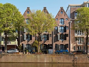 A row of brick buildings with arched windows and balconies. - YAYS Amsterdam Salthouse Canal by Numa (Amsterdam)
