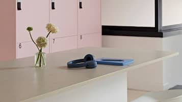 Une cuisine moderne avec des placards roses, un vase rempli de fleurs et un coin bar avec des tabourets.