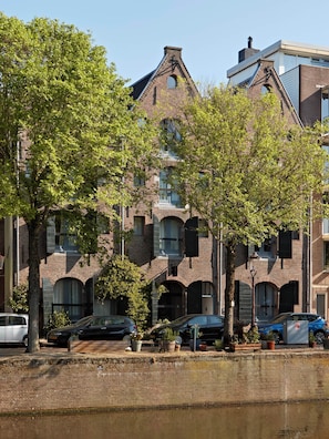 Um edifício de vários andares com fachada de tijolo, janelas grandes e telhado plano.