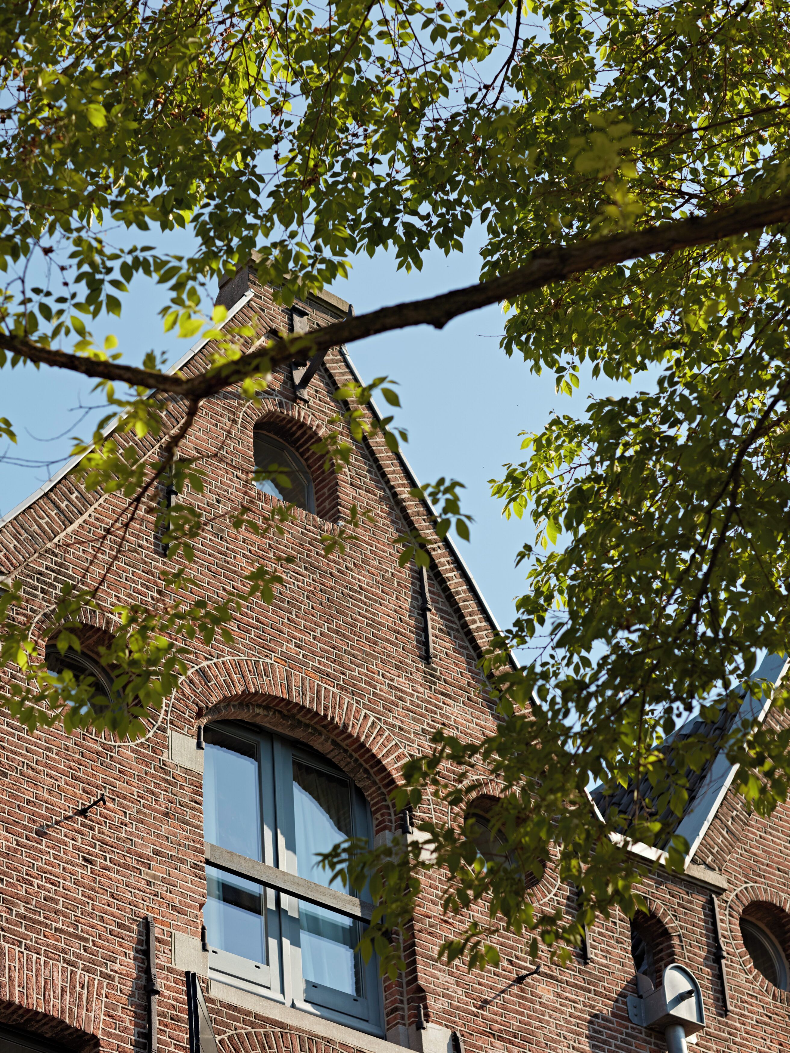 A brick building with arched windows and a visible bell tower.