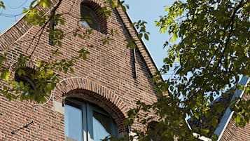 A brick building with arched windows and a visible bell tower.