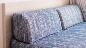 A bed with a wooden headboard and a blue patterned pillow. - Apartamentos Avenida - MC Apartamentos Ibiza (Ibiza Town)