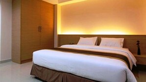 Un dormitorio moderno con una cama grande, un armario y una mesita de noche.